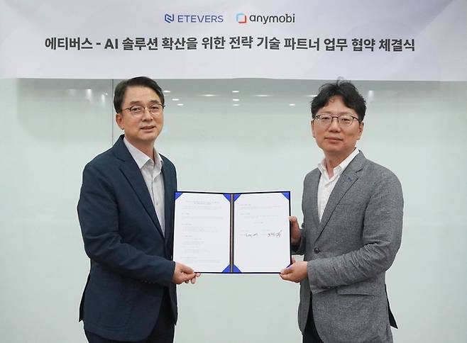 김범수 에티버스 대표(왼쪽)와 홍창민 애니모비 대표가 AI 번역 솔루션 ‘딥엘’ 확산을 위한 기술 파트너십 체결 후 기념 촬영을 하고 있다. [사진 = 애니모비]