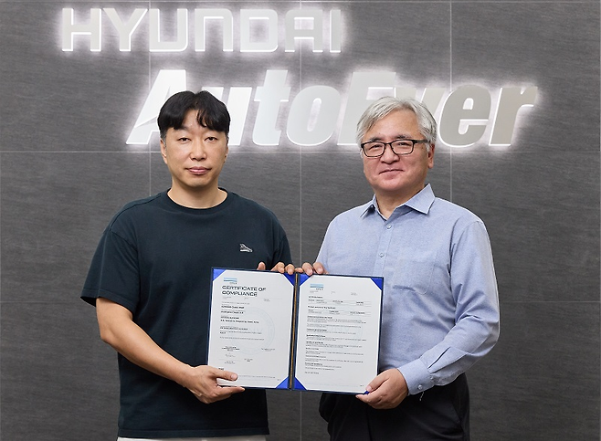 정지훈(왼쪽) 현대오토에버 차량전장SW센터장과 글로벌 인증기관 DNV Korea의 이장섭 대표이사가 ‘ASIL-D’ 인증서를 들고 기념촬영을 하고 있다. [현대오토에버 제공]