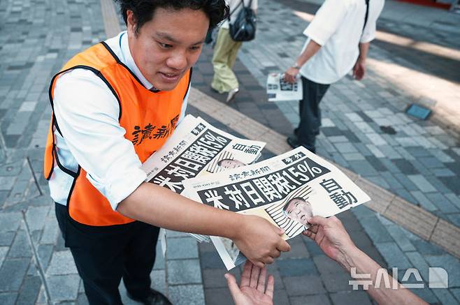 [도쿄=AP/뉴시스] 23일 일본 도쿄에서 요미우리 신문사의 한 직원이 도널드 트럼프 미국 대통령이 일본과 무역 협상을 완료했다는 내용을 보도한 신문 호외판을 배포하고 있다. 신문 1면에는 '미국, 일본에 15% 관세'라는 제목의 기사가 실렸다. 2025.07.24.