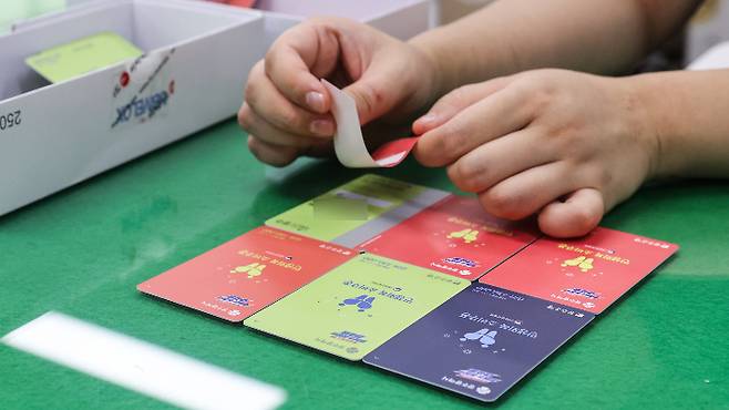 소득 수준에 따라 색상이 달라 논란이 된 광주시 소비 쿠폰 선불카드에 23일 밤에 광주 동구 행정복지센터 공무원이 스티커 부착하고 있다. 광주 동구 제공