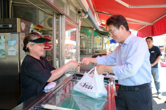 노관규 순천시장이 24일 순천 역전시장을 찾아 식품을 구입 후 민생회복 소비쿠폰으로 결재를 하고 있다. 사진 제공=순천시