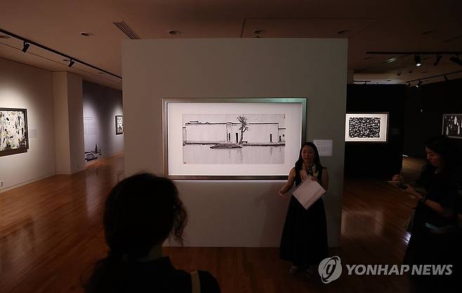 우관중 국내 첫 단독전 (서울=연합뉴스) 이재희 기자 = 24일 서울 서초구 예술의전당 서예박물관에서 열린 '우관중: 흑과 백 사이' 전시 프리뷰 행사에서 관계자가 작품을 설명하고 있다. 우관중의 대표작 17점을 소개하는 이번 전시는 다음 날부터 열리는 '홍콩 위크 2025'의 사전 오프닝 프로그램으로 10월 19일까지 열린다. 2025.7.24 scape@yna.co.kr