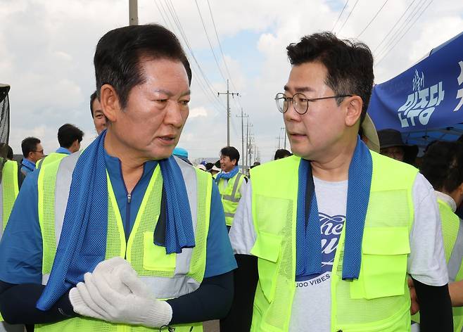 정청래(왼쪽), 박찬대 더불어민주당 당대표 후보가 21일 충남 예산 신안면 조곡리에서 수해복구 현장을 찾아 대화하고 있다. /뉴스1