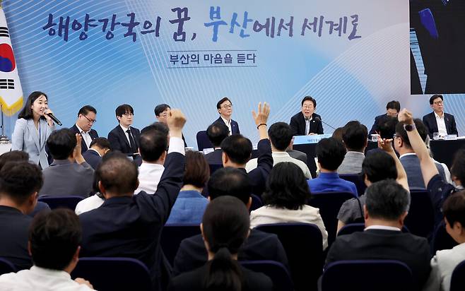 25일 부산 부경대에서 이재명 대통령이 참석한 가운데 열린 타운홀미팅 ‘부산의 마음을 듣다’ 간담회에서 시민들이 손을 들어 발언권을 요청하고 있다. 연합뉴스