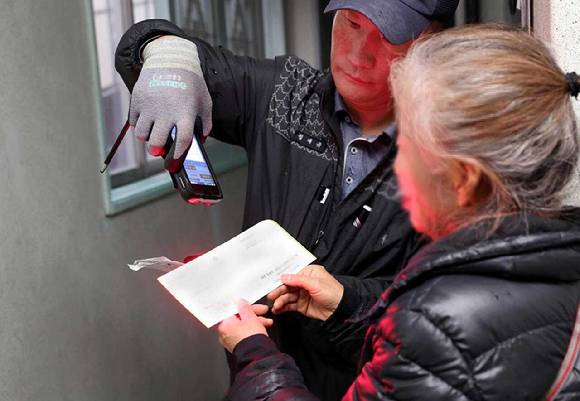 대전유성우체국 집배원이 한 가정에 복지 등기 우편물을 전달하고 있다. 기사와 무관한 사진. [사진=우정사업본부]