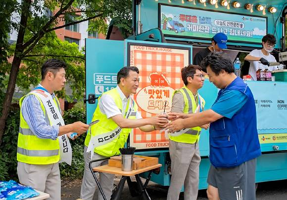 24일 경기도 수원시 소재 CJ대한통운 서브터미널에서 윤재승 CJ대한통운 O-NE 본부장(왼쪽에서 두 번째)이 택배기사에게 커피와 쿨링패치 등 여름나기 용품을 전달하고 있다. [사진=CJ대한통운]