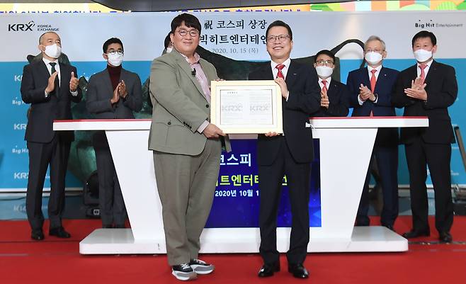 HYBE Chairman Bang Si-hyuk and then Korea Exchange Chairman Jung Ji-won pose for a photo during Big Hit Entertainment’s listing ceremony at the Korea Exchange office in Yeouido, western Seoul, on Oct. 15, 2020. [JOINT PRESS CORPS]