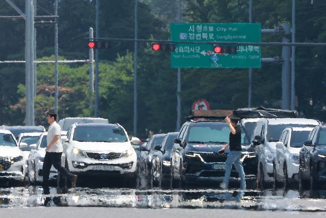 전국 대부분 지역에 폭염 특보가 발효된 25일 서울 영등포구 여의도 여의대로에 아지랑이가 피어오르고 있다. [연합뉴스]