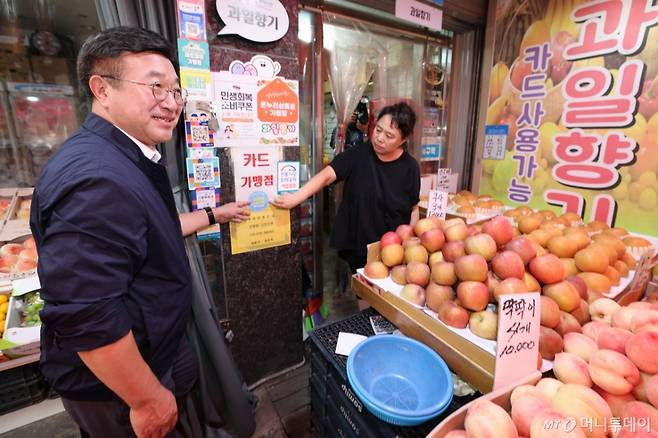 (서울=뉴스1) 오대일 기자 = 윤호중 행정안전부 장관이 24일 오후 서울 금천구 비단길 현대시장을 찾아 과일가게 상인과 함께 민생회복 소비쿠폰 사용가능 매장 스티커를 붙히고 있다. 2025.7.24/뉴스1  Copyright (C) 뉴스1. All rights reserved. 무단 전재 및 재배포,  AI학습 이용 금지. /사진=(서울=뉴스1) 오대일 기자