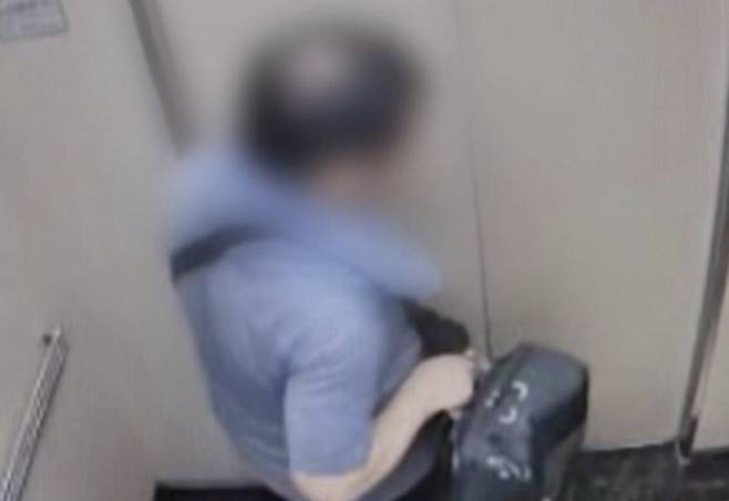 인천 연수구 송도의 한 아파트에서 지난 20일 아들을 살해한 A씨가 큰 가방을 들고 엘리베이터에 탄 모습. [YTN 캡처]