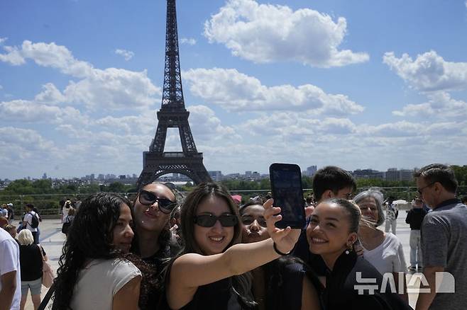 [서울=AP/뉴시스] 프랑스 파리를 찾은 관광객들이 에펠탑을 배경으로 사진을 찍고 있다. 2023.07.06