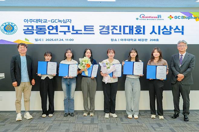 김용성 아주대학교 첨단바이오융합대학 학장(왼쪽)과 최영일 GC녹십자 R&D 부문 RED 본부장(오른쪽)이 24일 아주대 혜강관에서 열린 ‘공동연구노트 경진대회’ 시상식에서 수상 학생들과 기념촬영을 하고 있다. GC녹십자 제공