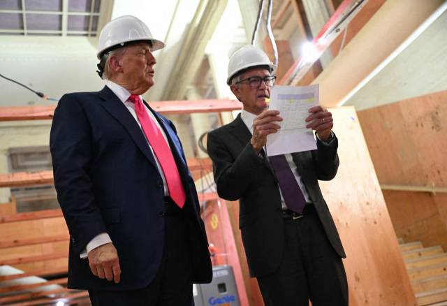도널드 트럼프 미 대통령이 24일(현지 시간) 워싱턴DC 소재 연준 리모델링 현장을 찾아 리모델링 비용이 많이 늘었다는 내용이 담긴 종이를 파월 연준 의장에 건냈고 파월 의장이 이를 살펴보고 있다. AFP연합뉴스