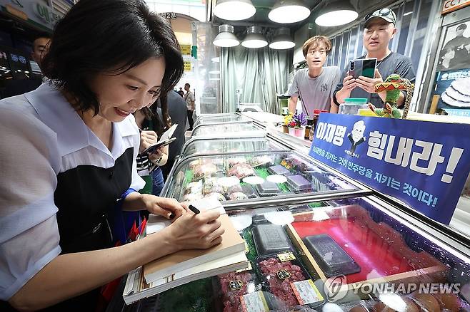 이재명 대통령 저서에 서명하는 김혜경 여사 (인천=연합뉴스) 홍해인 기자 = 김혜경 여사가 25일 인천 계양산전통시장을 방문해 한 상인의 요청으로 이재명 대통령 저서에 서명을 하고 있다. 2025.7.25 [대통령실통신사진기자단] hihong@yna.co.kr