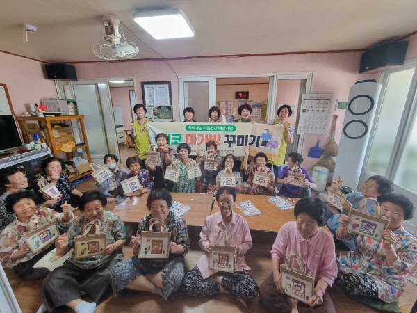 23일 의성군 비안면 장춘1리 경로당에서 열린 '에코 마가방 꾸미기' 프로그램에 참여한 어르신들이 완성한 가방을 들어 보이며 기념촬영을 하고 있다. 의성군