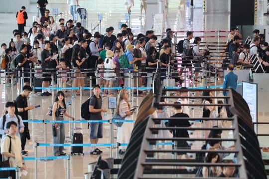 여름 휴가철이 시작된 지난 25일 서울 김포공항에서 여행객들이 신분확인을 위해 줄을 서 있다, 연합뉴스