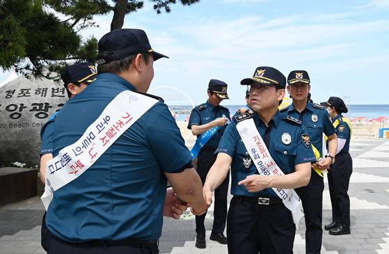 엄성규 강원경찰청장(오른쪽)이 본격적인 여름 휴가철을 앞둔 지난 2일 강릉 경포해수욕장을 찾아 여름경찰서 운영 현황을 점검하고 기초질서 지키기 캠페인을 하고 있다. [사진 강원경찰청]