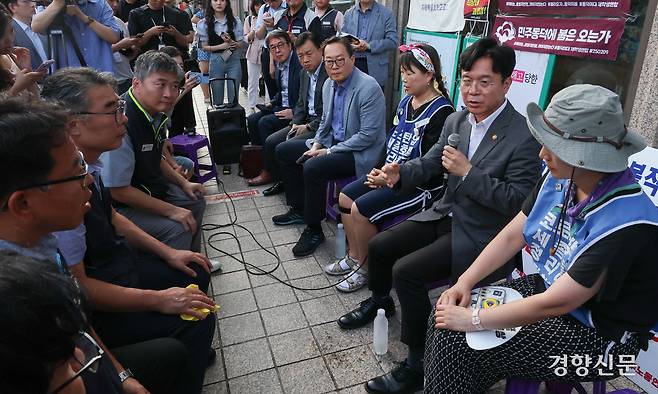 김영훈 고용노동부 장관이 25일 서울 중구 세종호텔 앞 농성장을 찾아 정리해고 철회 등을 촉구하며 163일째 고공농성 중인 고진수 민주노총 세종호텔 지부장과 전화 통화를 한 뒤 관계자들과 대화를 나누고 있다.  성동훈 기자