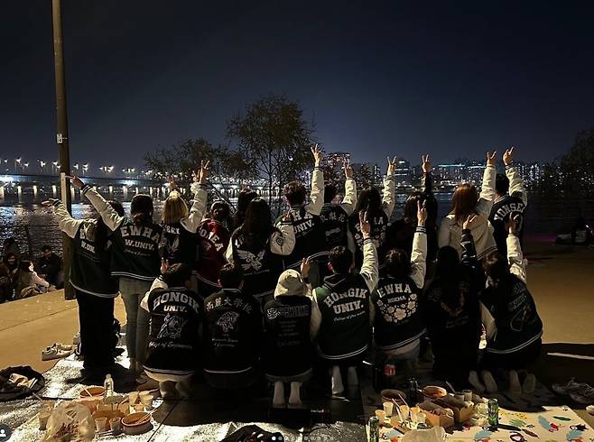 College students wearing gwajam pose for a group photo. [DEPORTE]
