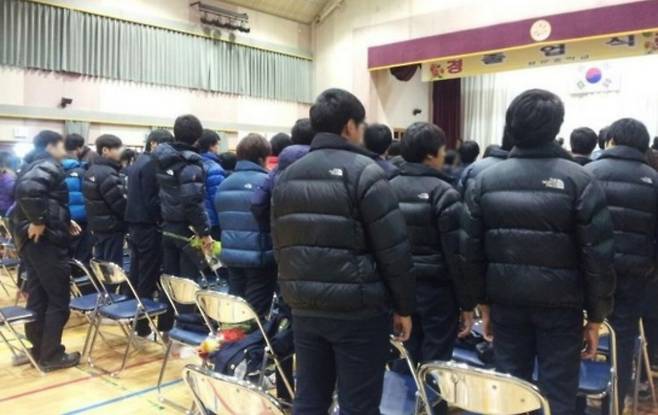 High school students wear The North Face padded jackets at a graduation ceremony. [SCREEN CAPTURE]