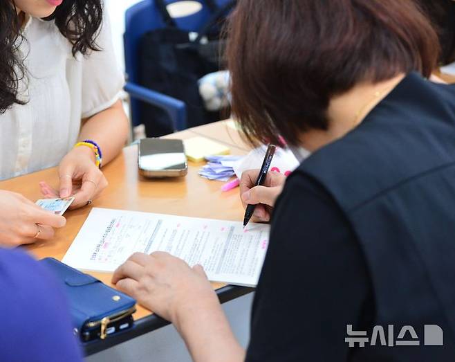 [청주=뉴시스] 서주영 기자 = 민생회복 소비쿠폰 1차 신청 첫날인 지난 21일 충북 청주시의 율량사천동행정복지센터 3층 대회의실에서 한 주민이 지원금 신청서를 작성하고 있다. 2025.07.21. juyeong@newsis.com