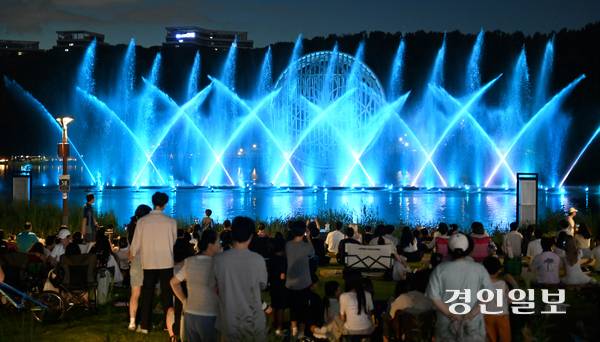 연일 폭염과 열대야가 이어지는 가운데 지난 26일 저녁 화성시 동탄호수공원에서 시민들이 멀티미디어 분수 쇼인 ‘루나쇼’를 보며 더위를 식히고 있다. 2025.7.26 /최은성기자 ces7198@kyeongin.com
