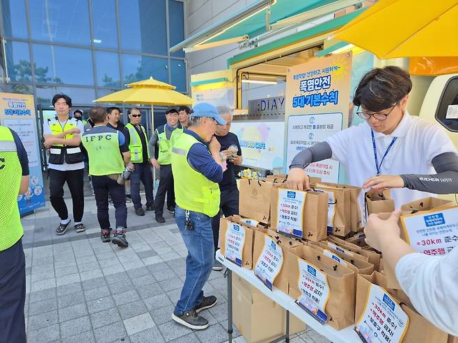 인천항만공사 직원들이 인천항 국제여객터미널 및 부두 현장 근로자에게 지원 물품을 전달하고 온열질환 예방수칙을 안내하고 있다 <인천항만공사 제공>