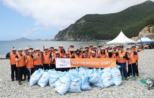 한화오션 임직원과 지역 주민이 지난 21일 여차해수욕장에서 ‘오션 플로깅’ 활동을 마친 뒤 지속 가능한 해양 환경을 위한 실천 의지를 다짐하고 있다. 한화오션 제공