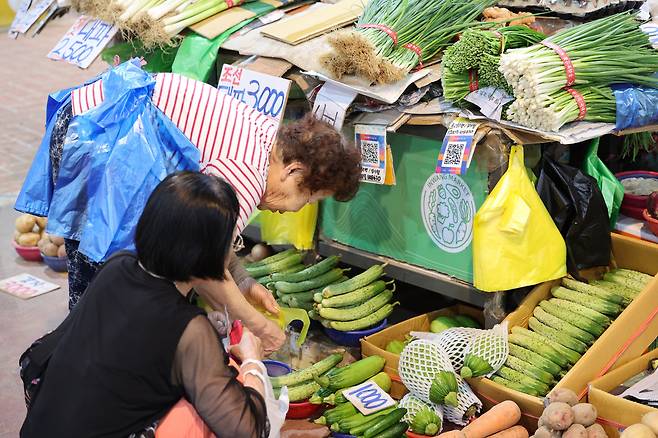 서울의 한 전통시장에서 한 상인이 비닐봉투를 허리에 두른 채 장사를 하고 있다./뉴스1
