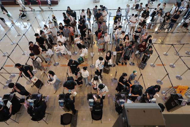 여름 휴가철이 시작된 지난 25일 서울 김포공항에서 여행객들이 신분확인을 위해 줄을 서 있다. 연합뉴스.