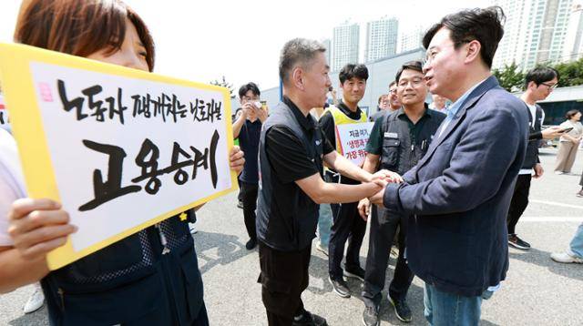 김영훈(오른쪽) 고용노동부 장관이 26일 경북 구미시 한국옵티칼하이테크에 방문해 금속노조 조합원들과 인사하고 있다. 고용부 제공
