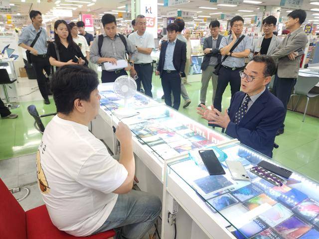 신승한(오른쪽) 방송통신위원회 시장조사심의관이 23일 서울 광진구 강변테크노마트 휴대폰 판매점을 방문해 단말기유통법 폐지에 따른 변경제도 이행 여부 등을 점검하고 있다. 방송통신위원회 제공