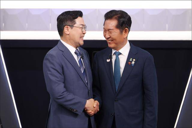 박찬대(왼쪽), 정청래 더불어민주당 당대표 후보가 27일 서울 여의도 KBS 신관 공개홀에서 TV토론회 시작 전 악수를 하고 있다. 뉴스1