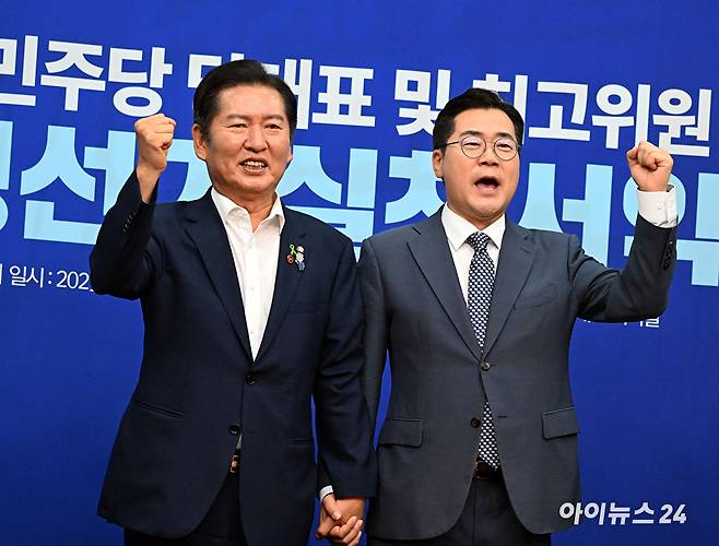 더불어민주당 정청래(왼쪽)·박찬대 당대표 후보가 15일 국회에서 열린 공명선거실천서약식에서 서약서에 서명한 뒤 기념촬영 하고 있다. [사진=곽영래 기자]
