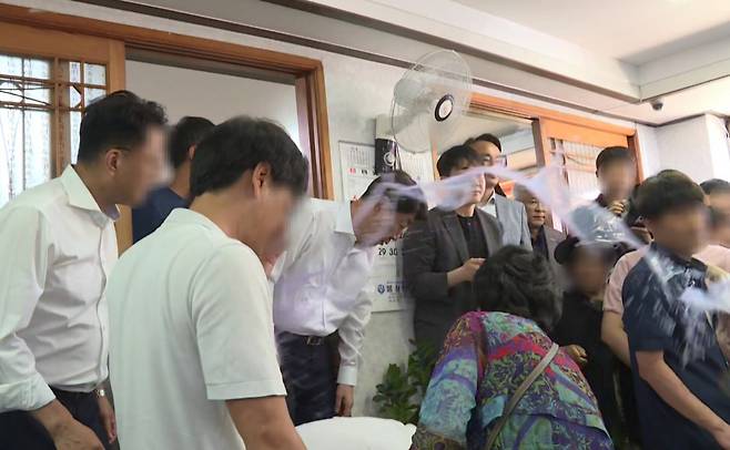 우범기 전주시장이 지난 25일 완주군 봉동읍 생강골 전통시장 내 한 식당에서 통합 찬성 단체 회원 10여명과 오찬 간담회를 하는 데 대해 통합 반대 측 군민 10여명이 항의하는 도중 한 군민이 컵에 있던 물을 우 시장 얼굴에 끼얹고 있다. 사진 독자