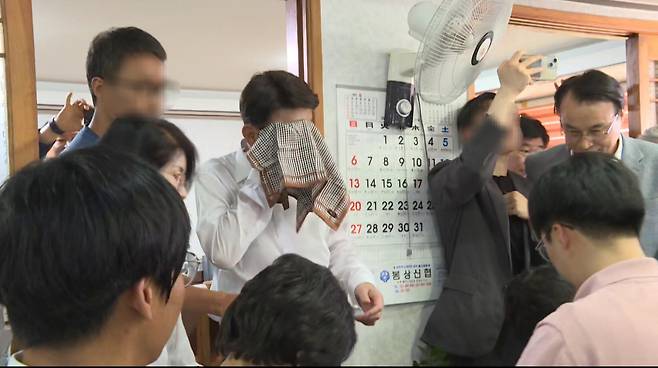 전주·완주 통합에 반대하는 완주군민에게 물벼락을 맞은 우범기 전주시장이 아무 말 없이 손수건으로 얼굴을 닦고 있다. 사진 독자