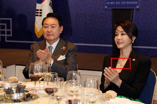 2022년 6월 29일(현지시간) 스페인 마드리드 만다린 오리엔탈 리츠호텔에서 열린 동포 만찬간담회에서 윤석열 전 대통령 부부가 박수를 치고 있는 모습으로, 당시 김건희 여사가 착용한 반클리프 목걸이 모습. 연합뉴스 제공