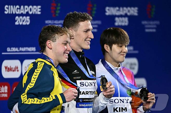 김우민(오른쪽)이 27일 열린 2025 싱가포르 세계수영선수권대회 남자 자유형 400m 결선에서 3분42초60의 기록으로 동메달을 획득했다. 루카스 메르텐스(가운데)가 금메달을 목에 걸었고, 새무얼 쇼트(왼쪽)가 은메달을 가져갔다. ⓒ AFP=뉴스1