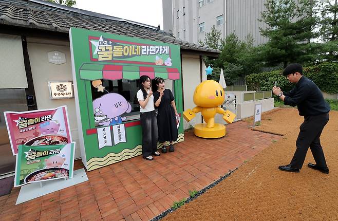 지난 16일 대전 동구 꿈돌이네 라면가게 앞, 꿈돌이라면 캐릭터를 배경으로 시민들이 기념사진을 남기고 있다. /신현종 기자