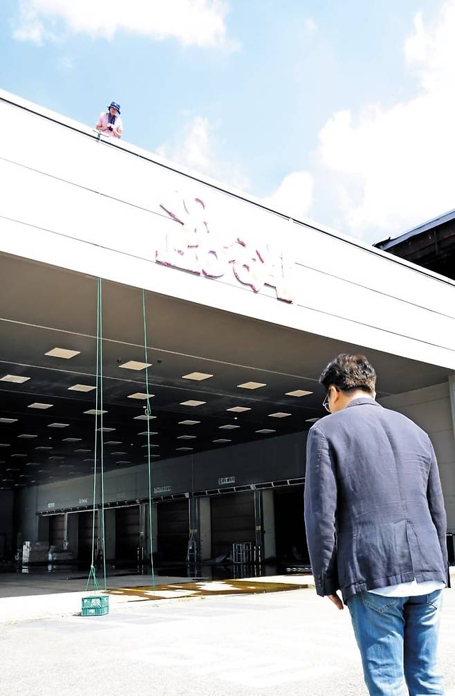 지난 26일 경북 구미시 한국옵티칼하이테크 공장을 찾은 김영훈 고용노동부 장관이 옥상에서 농성 중인 노동자와 면담을 시도하는 모습./고용노동부