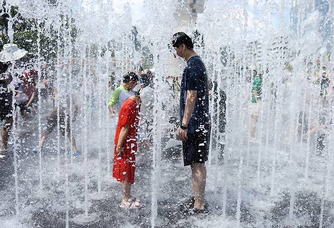 폭염이 이어지는 27일 서울 광화문광장 분수대에서 시민들이 물놀이하고 있다. 연합뉴스
