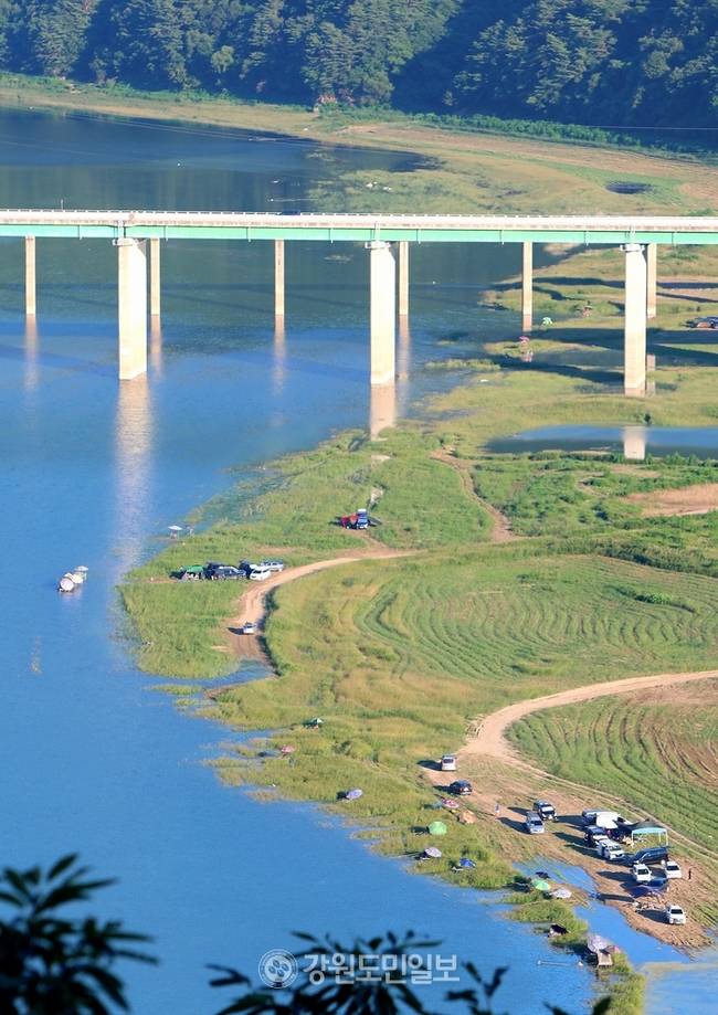 ▲ 지난 27일 폭염 속에 인제군 인제대교 아래에 위치한 소양호 변에서 낚시꾼들이 붕어낚시 삼매경에 빠져 있다. 이동명 기자