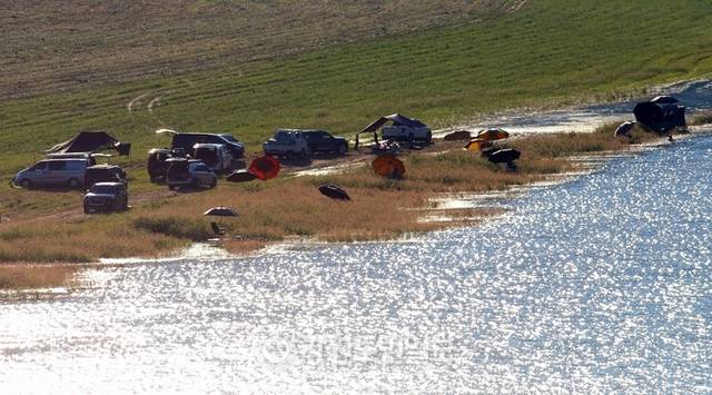 ▲ 지난 27일 폭염 속에 인제군 인제대교 아래에 위치한 소양호 변에서 낚시꾼들이 붕어낚시 삼매경에 빠져 있다.