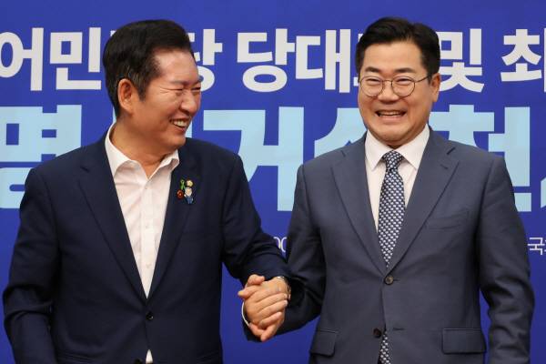 ▲ 더불어민주당 정청래·박찬대(오른쪽) 당대표 후보가 15일 서울 여의도 국회에서 열린 공명선거 실천 서약식에서 서약문에 서명한 뒤 손을 잡고서 기념촬영 하고 있다. ⓒ연합뉴스