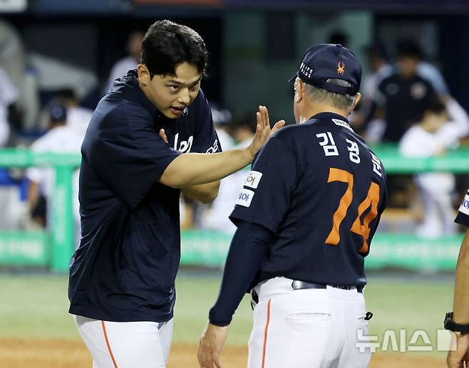 [서울=뉴시스] 홍효식 기자 = 22일 서울 송파구 잠실야구장에서 열린 2025 KBO리그 한화 이글스와 두산 베어스의 경기, 2-1로 승리한 한화 선발투수 문동주와 김경문 감독이 하이파이브 하고 있다.이번 승리로 한화는 단일 시즌 두 번째 10연승을 달성하며, 구단 최초 기록을 세웠다. 2025.07.22. yesphoto@newsis.com