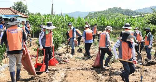 집중호우 피해 지역 복구 위해 자원봉사하는 한전 임직원들. 한국전력 제공.