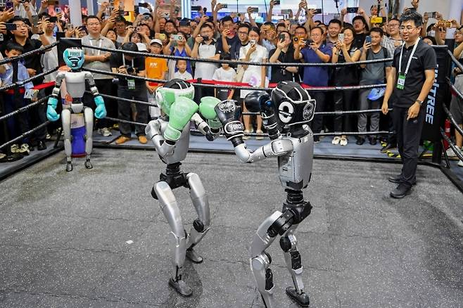 中 ‘AI 대회’ 로봇 복서들의 강철 펀치 - 26일(현지시간) 중국 상하이 엑스포센터에서 열린 ‘2025 세계인공지능대회’(WAIC) 전시회장에서 휴머노이드 로봇들이 권투 경기를 벌이고 있다. 이날 리창 중국 총리는 미국을 겨냥해 “인공지능(AI) 기술이 소수 국가·기업의 전유물이 돼선 안 된다”며 “중국 정부는 세계인공지능협력기구(WAICO) 설립을 제안한다”고 말했다. 상하이 AFP 연합뉴스
