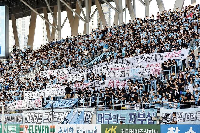 대구FC 서포터들이 27일 포항 스틸러스와의 홈 경기에 앞서 구단 운영을 비판하는 문구가 담긴 걸개를 들고 서 있다. 프로축구연맹 제공