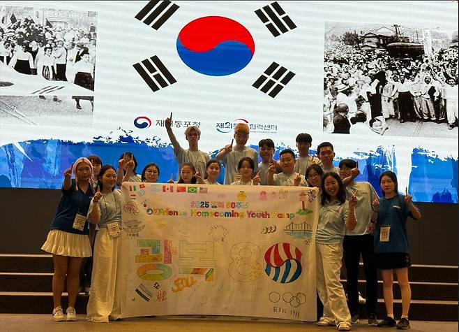 광복 80주년 기념 '태극기 만들기' 이벤트 (부산=연합뉴스) 박현수 기자 = 이지훈(뒷줄 왼쪽서 3번째) 씨가 지난 26일 부산 그랜드 모먼트 유스호스텔에서 열린 광복 80주년 기념 '태극기 만들기' 이벤트에서 동포 친구들과 함께 그린 태극기 그림을 들고 기념사진을 찍고 있다. 2025. 07. 27.  phyeonsoo@yna.co.kr