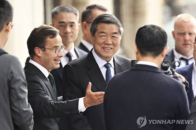 무역협상 위해 스웨덴 스톡홀름 도착해 울프 크리스테르손 스웨덴 총리와 이야기 나누는 허리펑 중국 부총리(가운데). [AP=연합뉴스. 재판매 및 DB 금지]